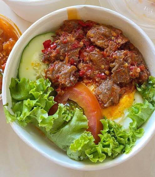 Rice bowl dengan topping krengsengan daging sapi bersama sambal goreng yang pedas.